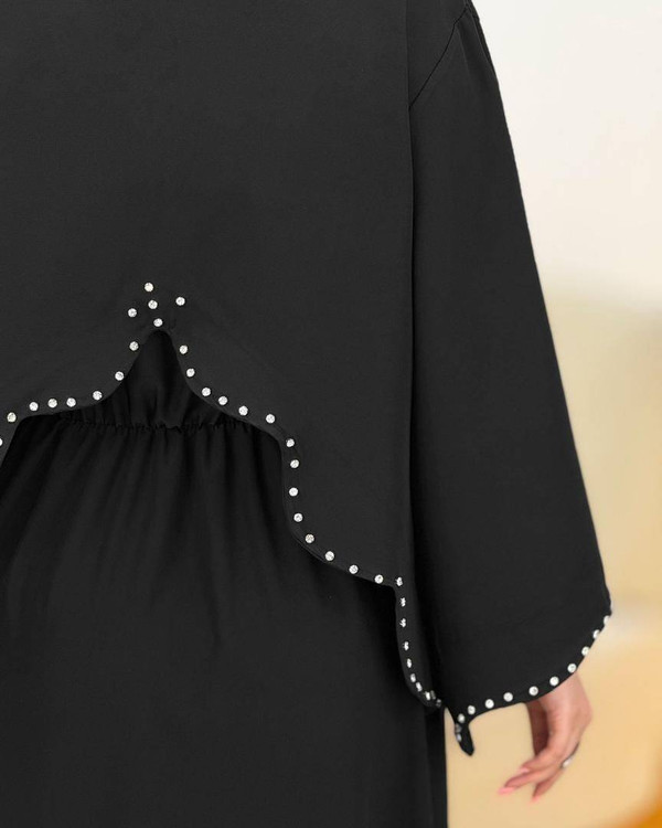 نمای نزدیک سنگدوزیهای ظریف روی یقه و لبههای کت مشکی مجلسی